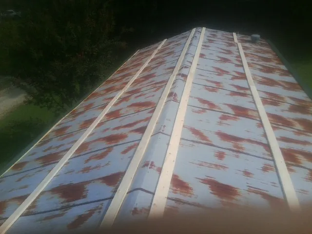 Rusted metal roof panels with new wood purlins before replacement — Storm Damage Roof Repair in Libertyville by Roofing Brothers